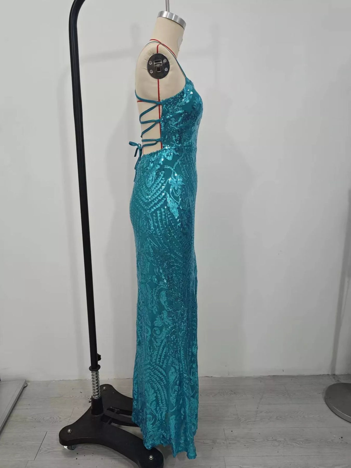 Turquoise sequin bodycon evening dress on mannequin with lace-up back detail