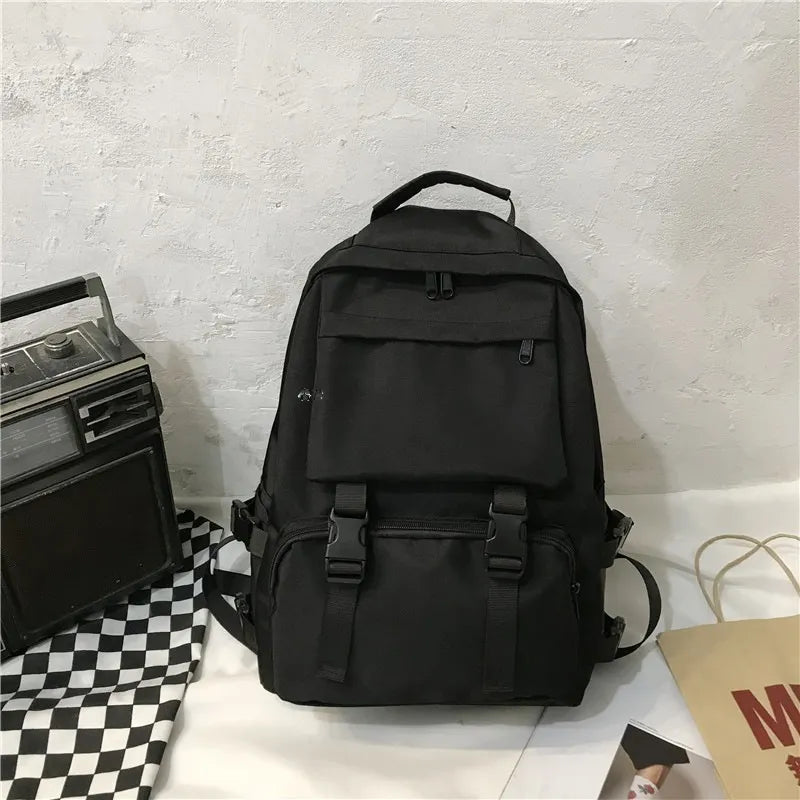 Black backpack with front flap pocket and dual adjustable shoulder straps, front view