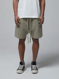 Men's sage waffle shorts with drawstring tie and side pockets, knee-length