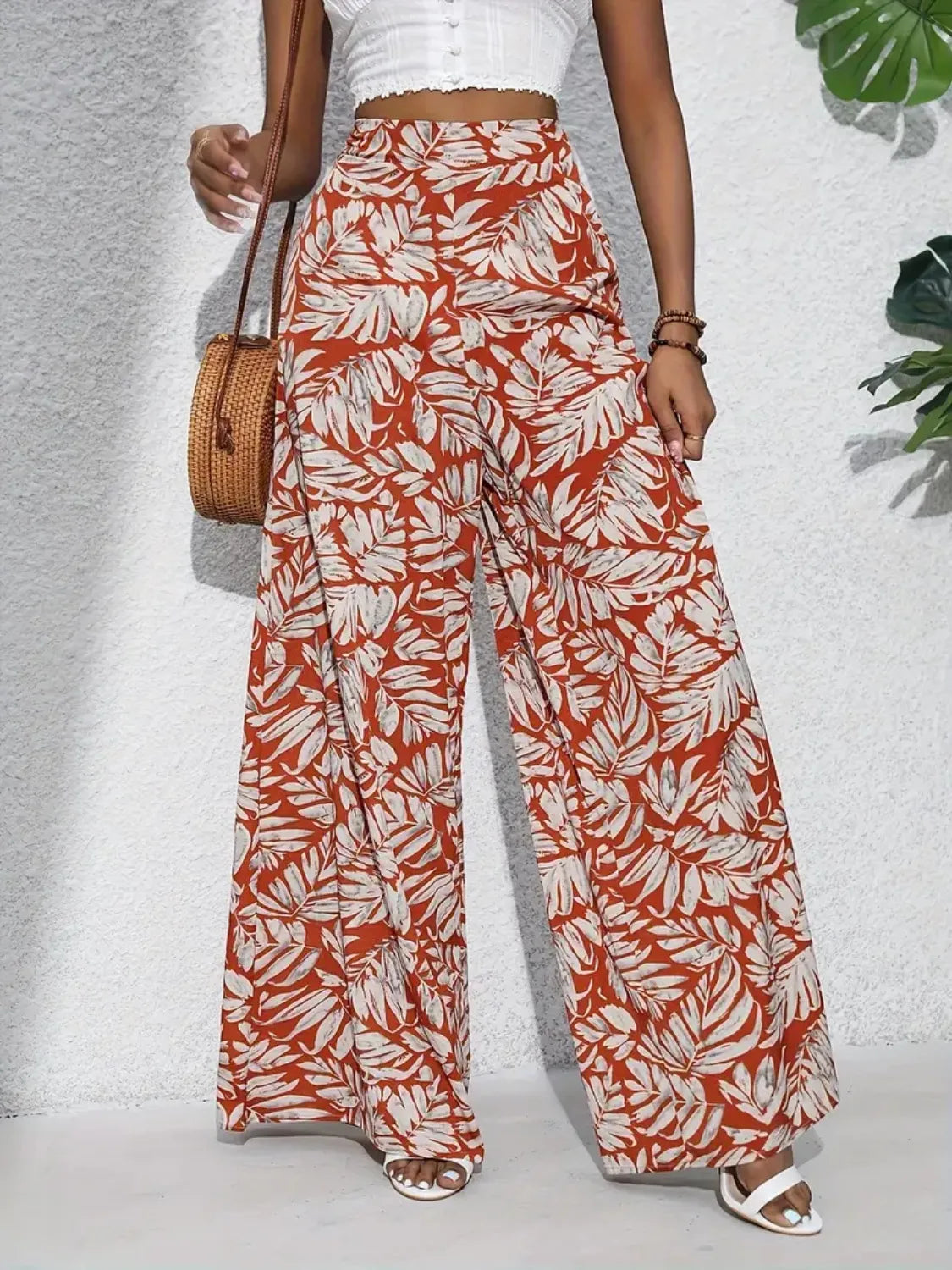 High-waist wide-leg pants with rust-and-white leaf print and flowing wide legs