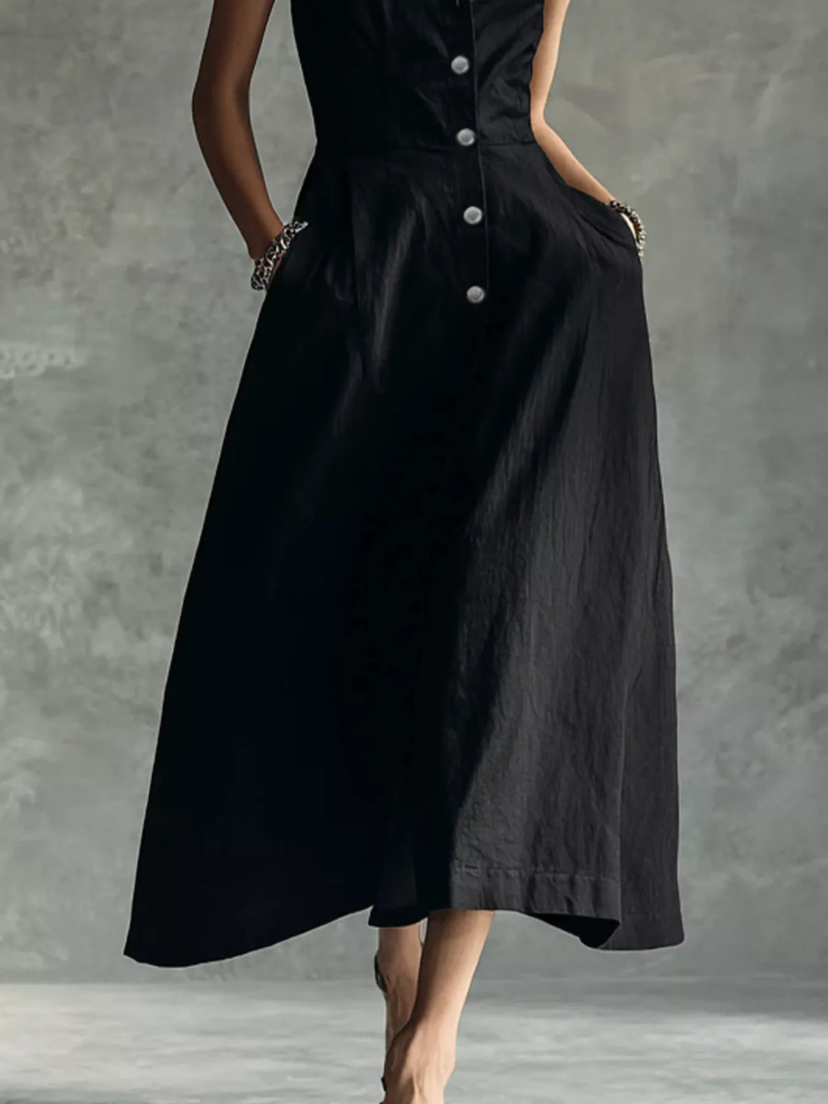 Black sleeveless midi button shirt dress with pointed collar and flared A-line hem.
