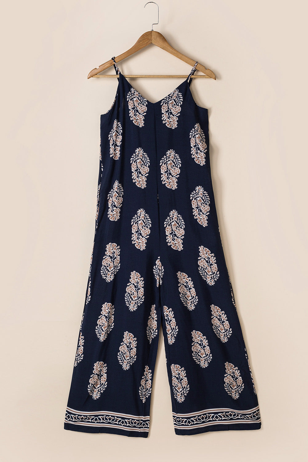 Dark blue printed V-neck sleeveless jumpsuit on hanger, wide-leg pants
