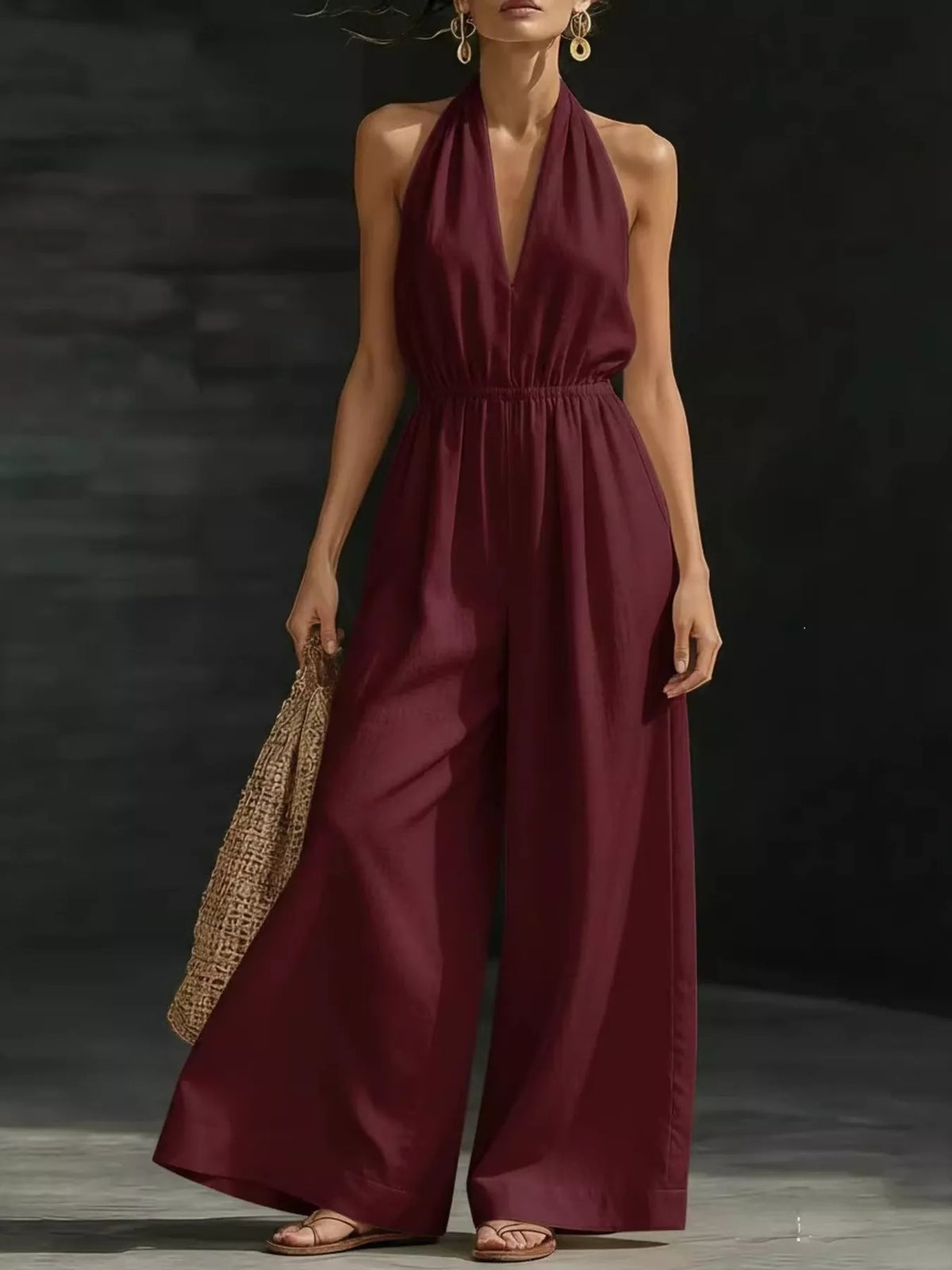 Burgundy halter-neck wide-leg jumpsuit with deep V neckline and gathered waist