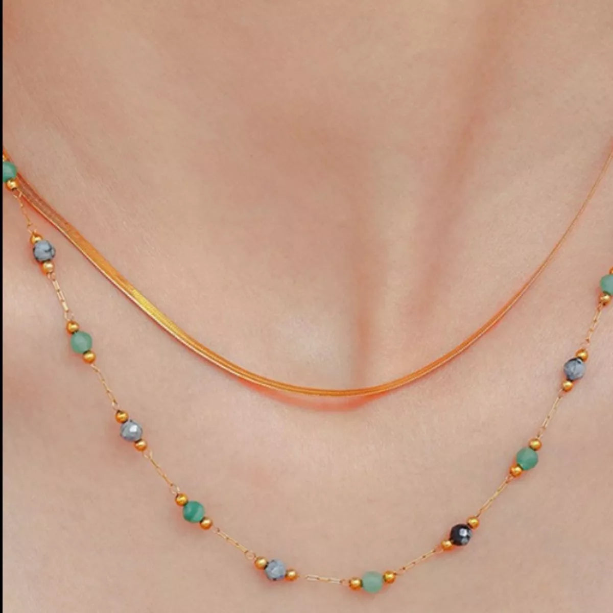 Two-layer gold necklace with multicolor bead drops along a curved center strand