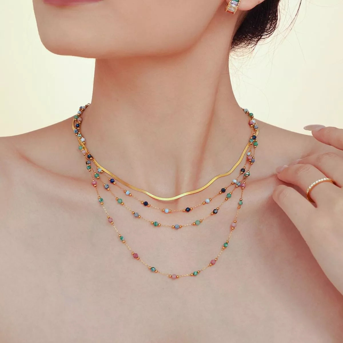 Layered gold-plated necklace with multicolor bead strands and tiny round blue beads