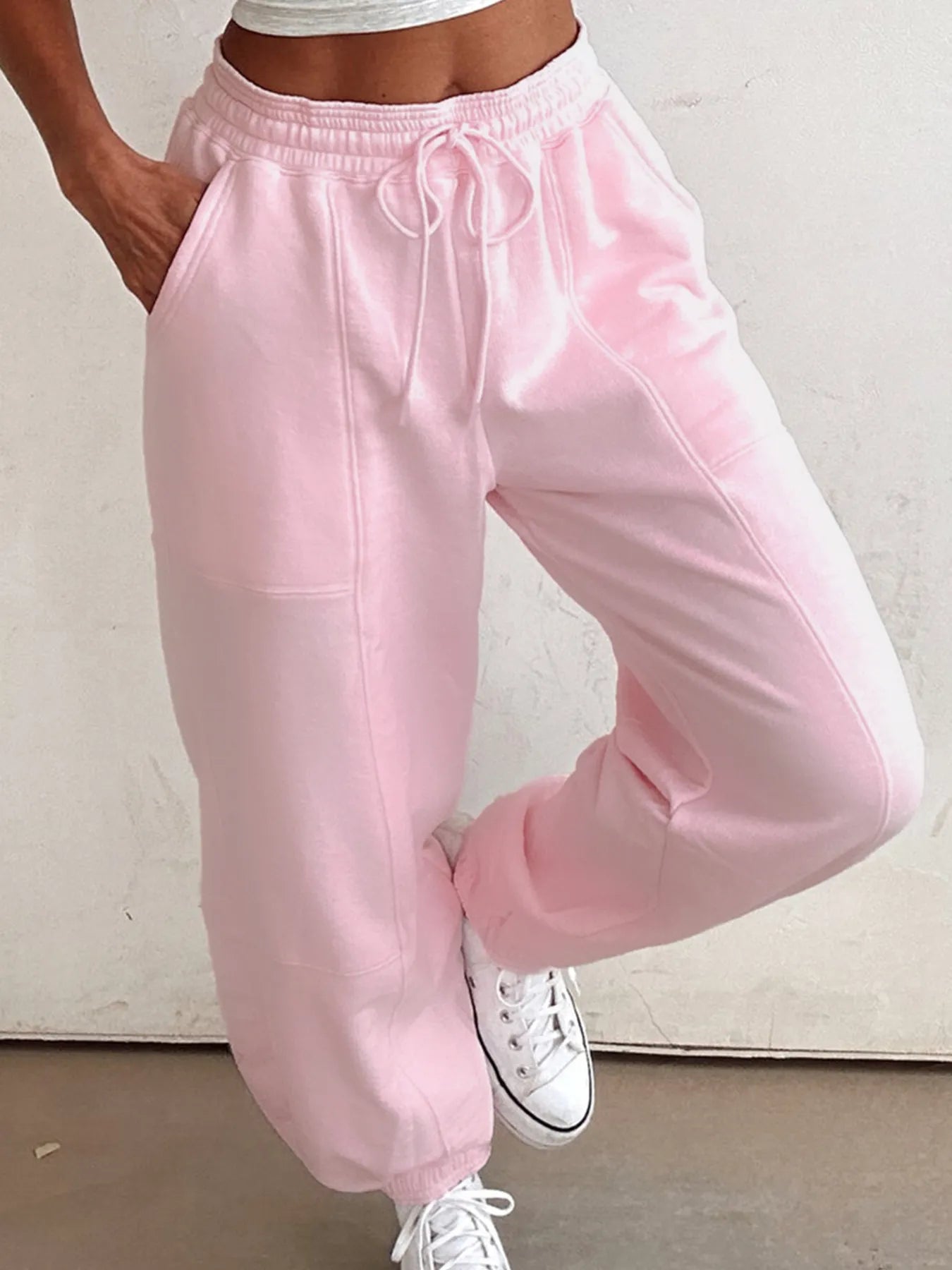 Pink drawstring sweatpants with elastic waistband and tapered cuffs