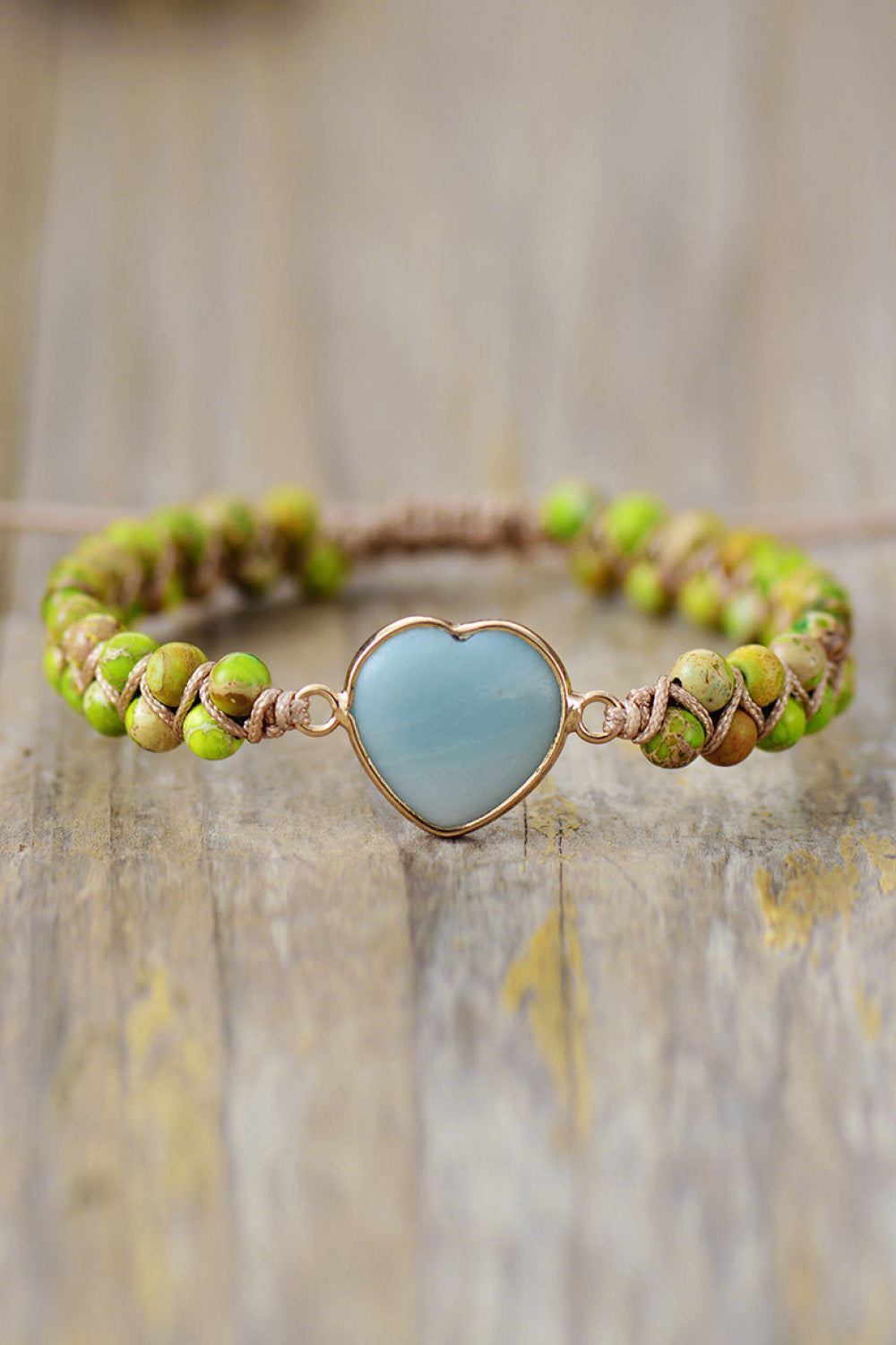 Green beaded bracelet with light blue heart-shaped stone charm and silver-tone clasp