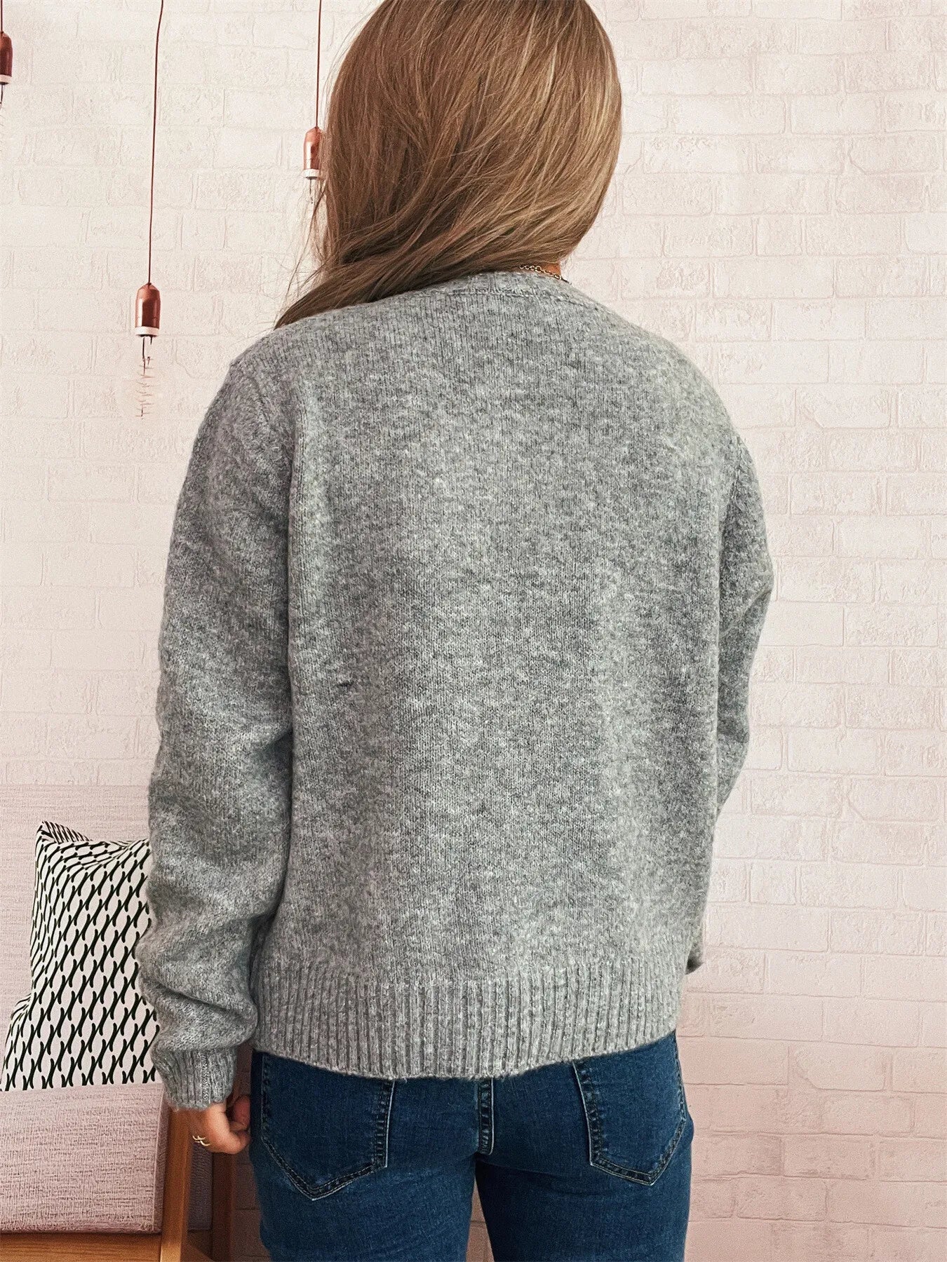 Gray cardigan back view with ribbed hem and long sleeves, knit texture.