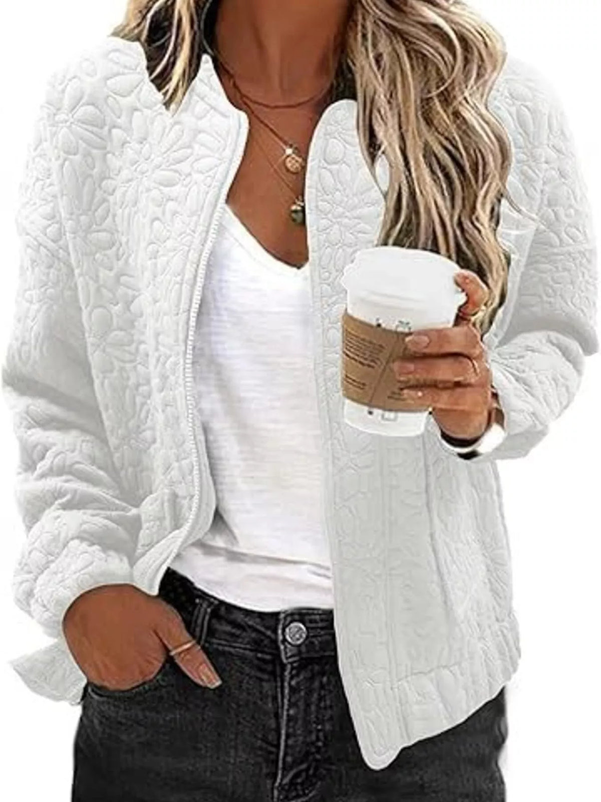 Quilted zip-front floral jacket in white, open front and textured quilting.