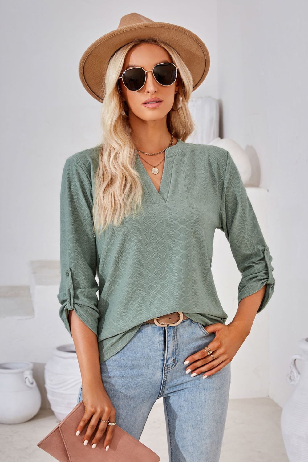Sage green V-neck roll-tap sleeve blouse with textured diamond-like print.