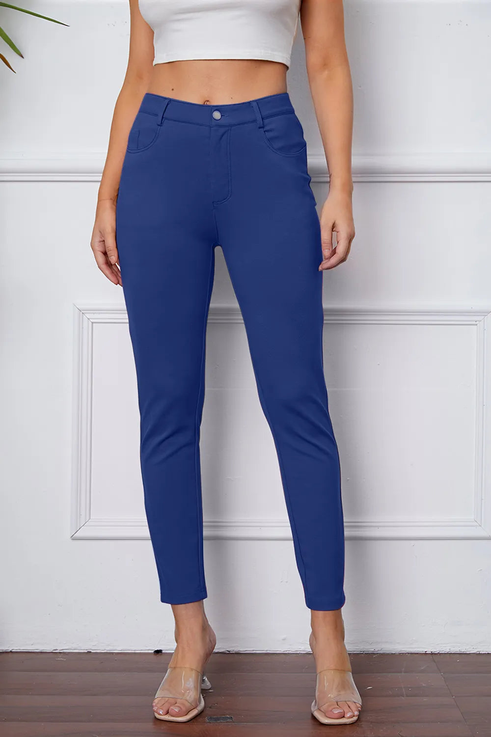 Women's royal blue stretch pants with button, belt loops, and ankle-length slim fit