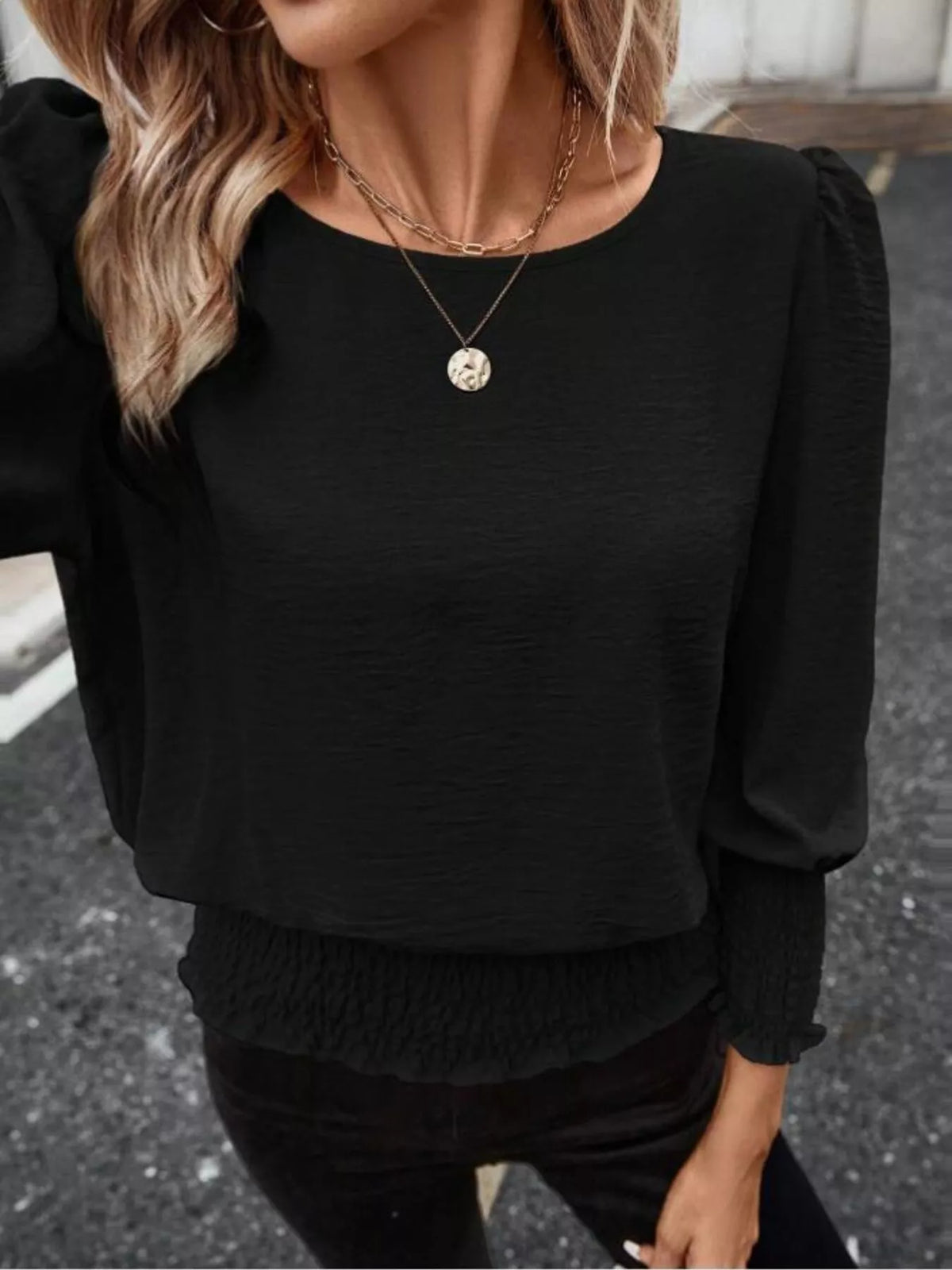 Black puff-sleeve smocked polyester blouse, round neckline with gathered lower hem