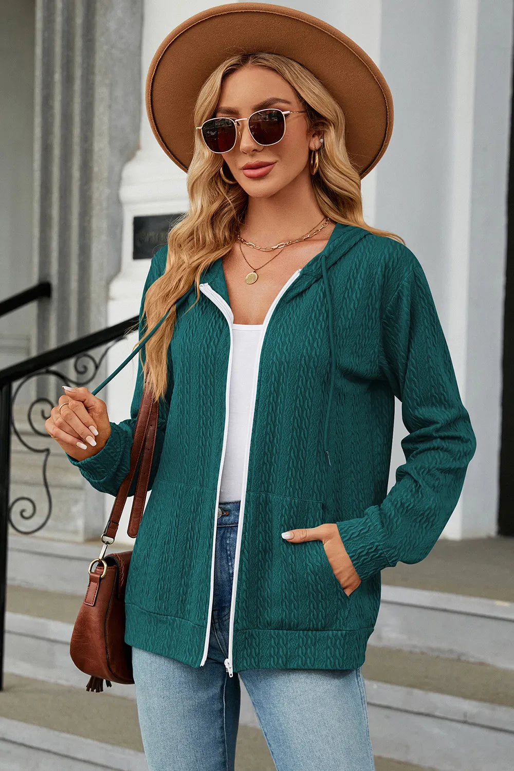 Turquoise drawstring zip-up hoodie with hood, white-trim zipper, and front kangaroo pocket