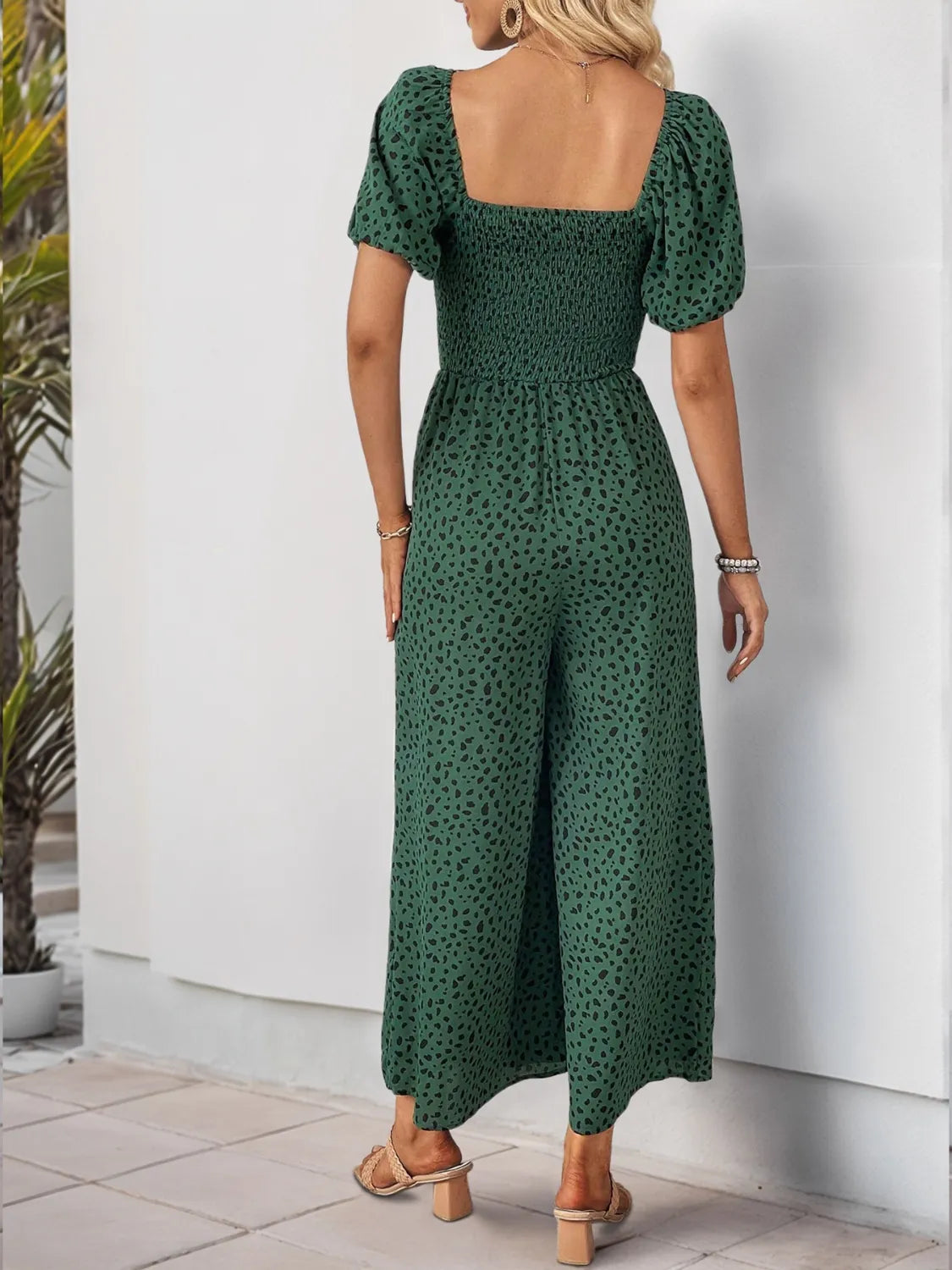 Back view of dark green printed square-neck puff-sleeve jumpsuit, wide-leg pants