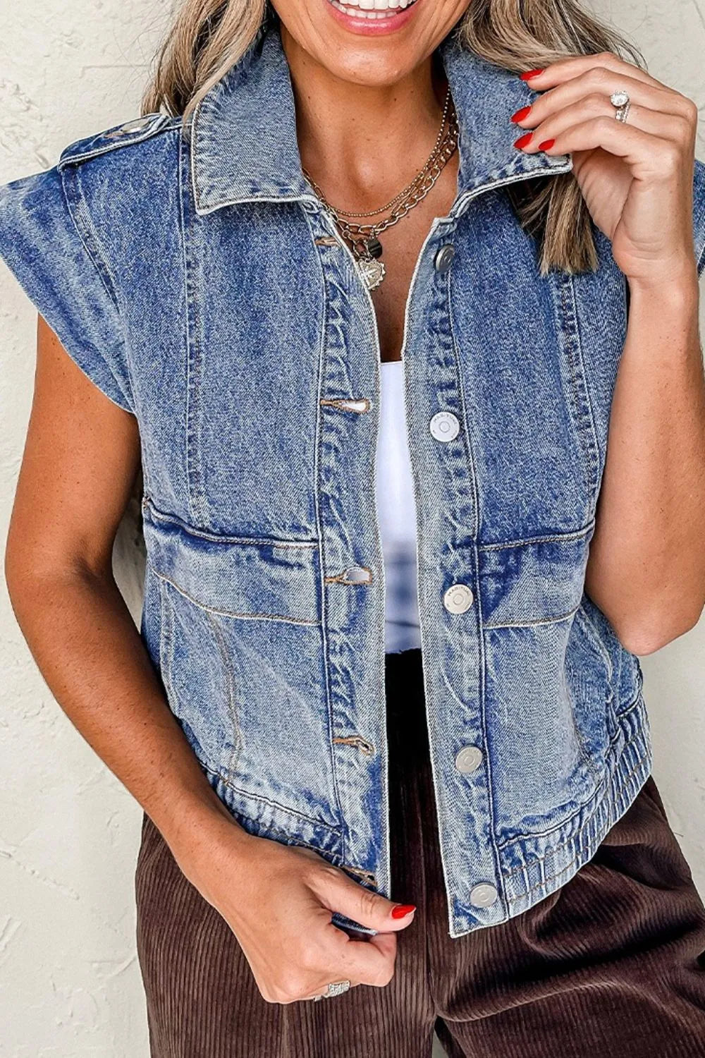 Medium-wash denim button-up cap sleeve jacket with button front and chest patch pockets