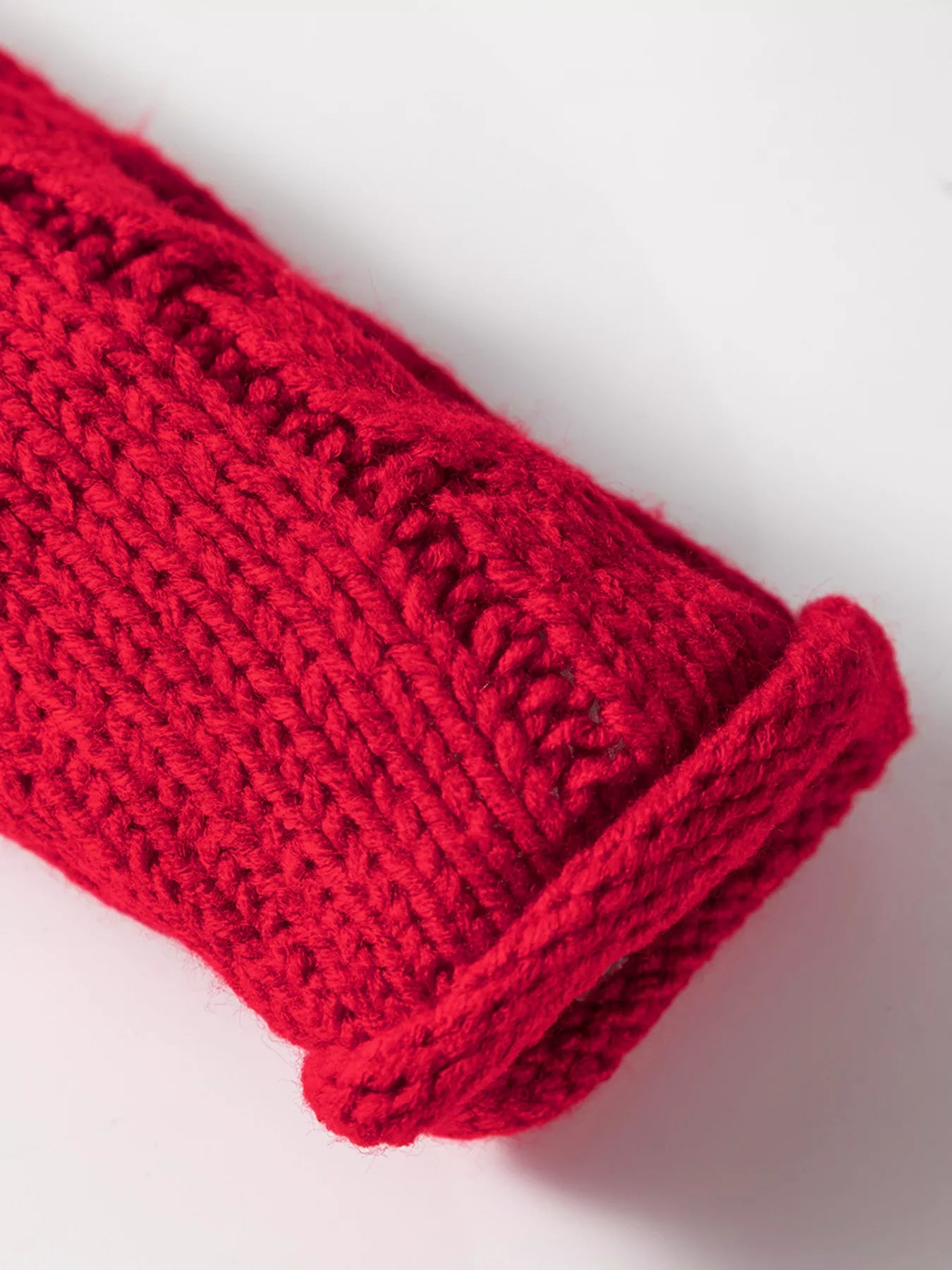 Deep red knit sweater cuff with ribbed trim
