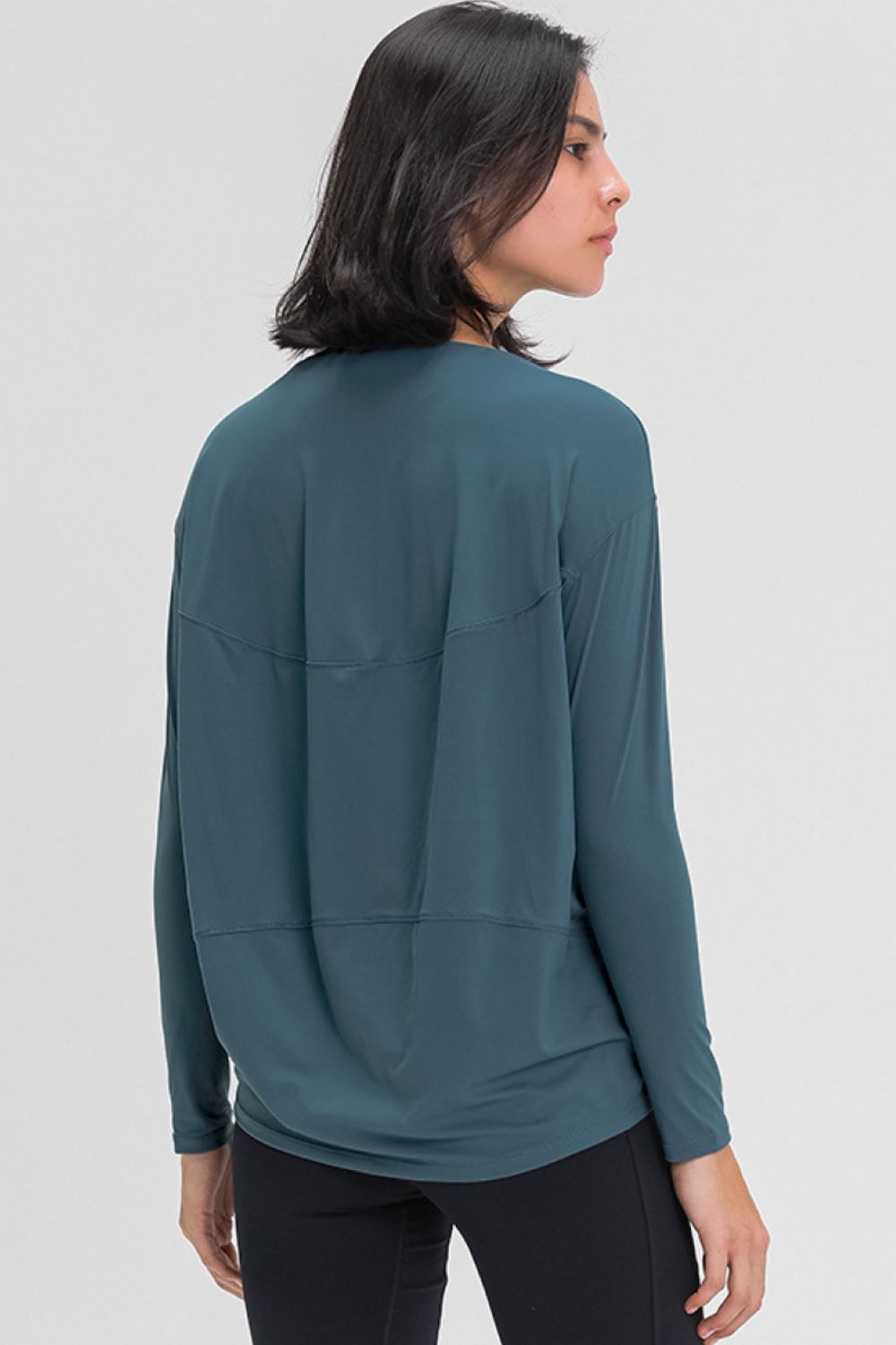 Loose-fit active top in deep teal, back view with stitched yoke detail.