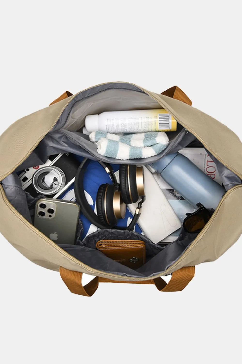 Open travel duffel interior with mesh pocket, divider, and folded packing items