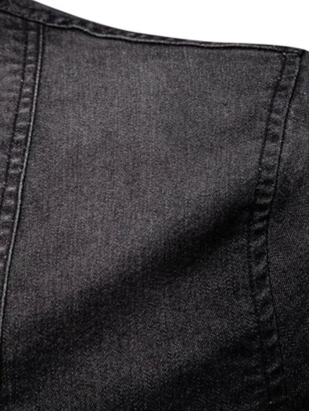 Dark denim fabric with visible seam stitching and textured weave