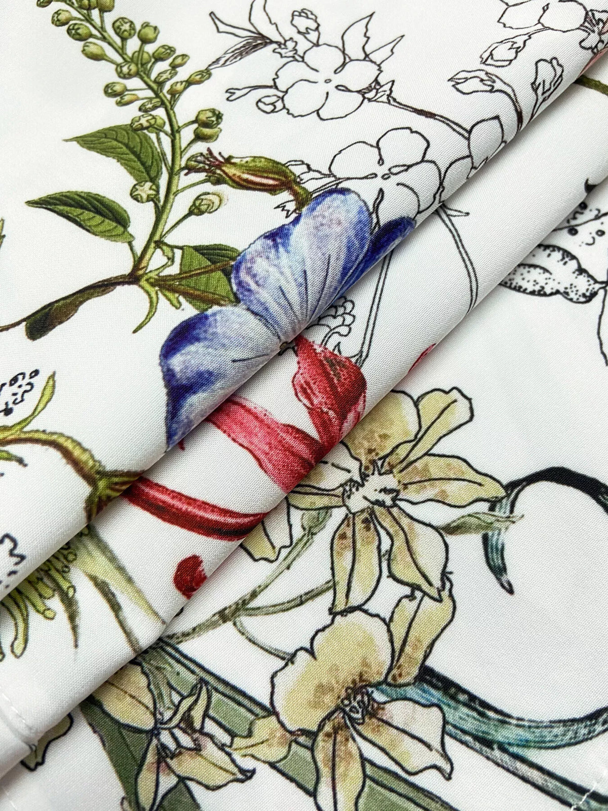 Floral print blouse fabric detail: white base with blue and red flowers
