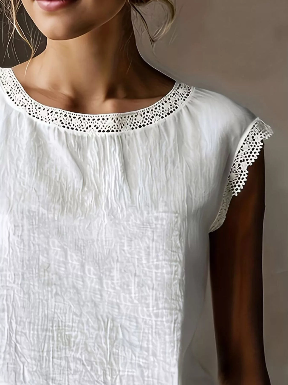 White sleeveless blouse with lace-trim round neckline and detailed lace shoulder trim