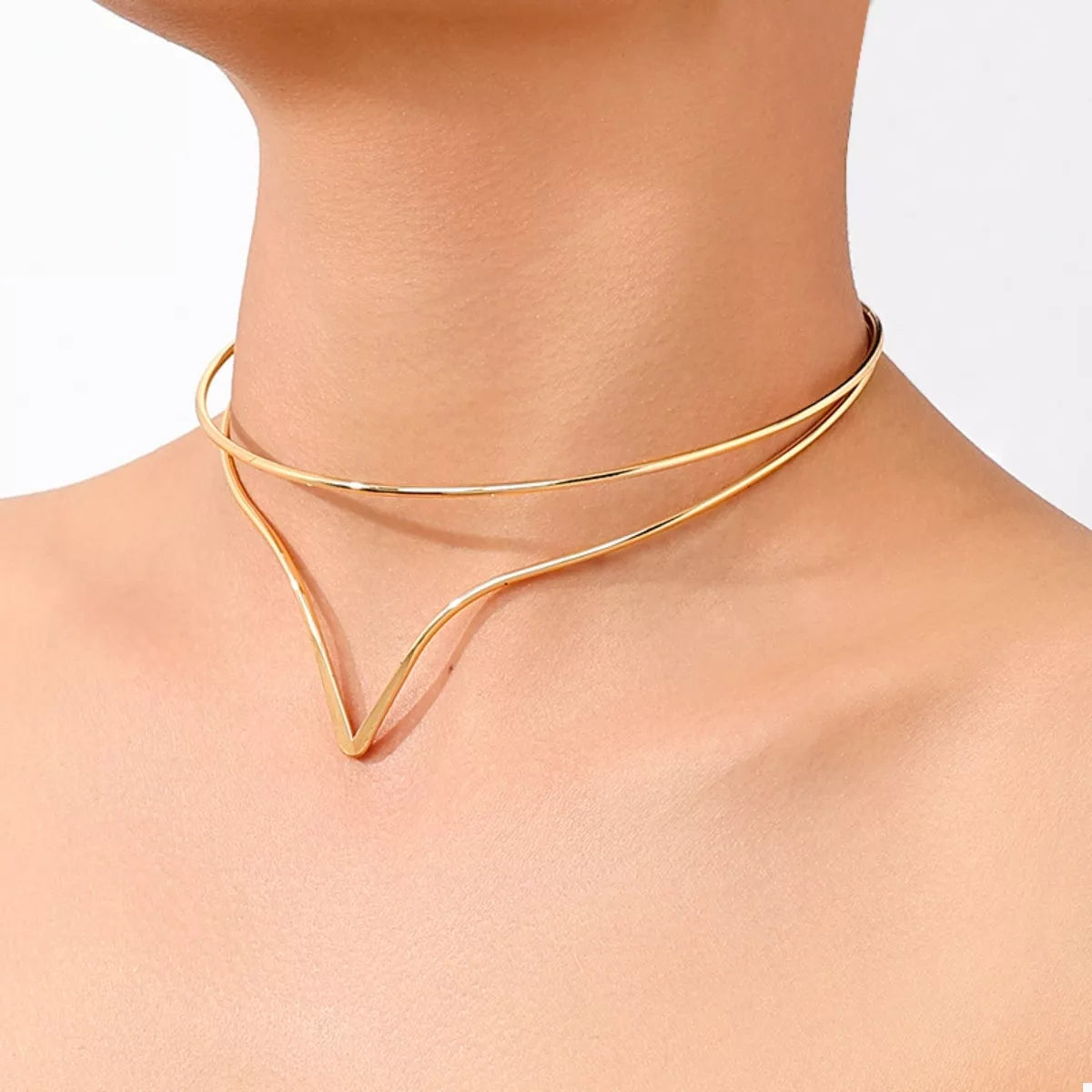 Gold double-layer V-shaped choker necklace on neck with two thin curved bands