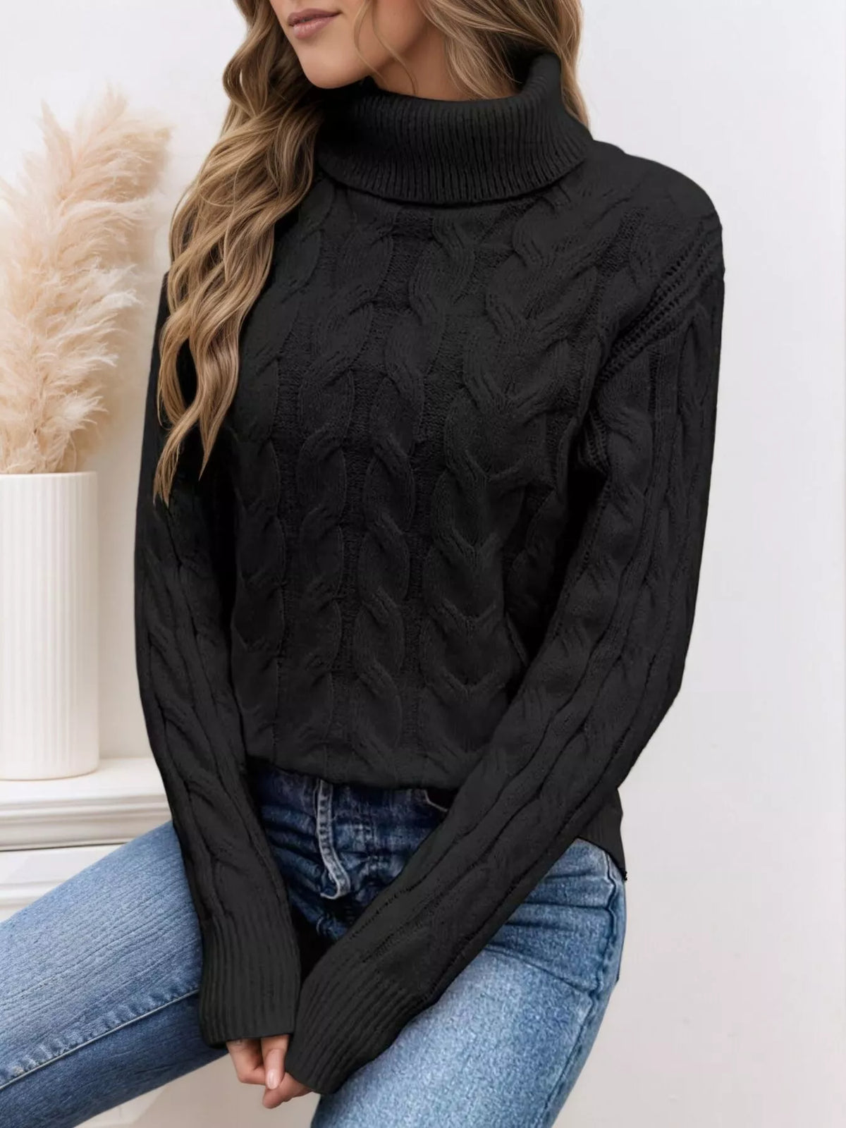 Black cable knit turtleneck sweater with long sleeves and chunky cable texture