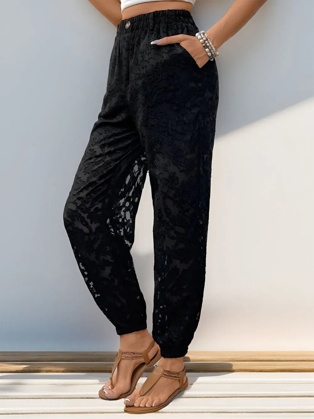 Black lace elastic-waist pants with front pockets and roomy tapered legs