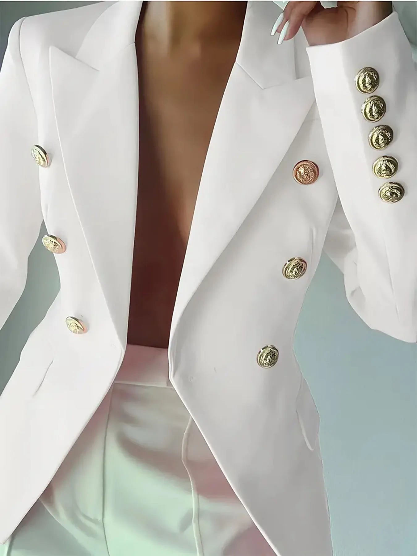White blazer with deep V lapels, gold buttons, and flap pockets
