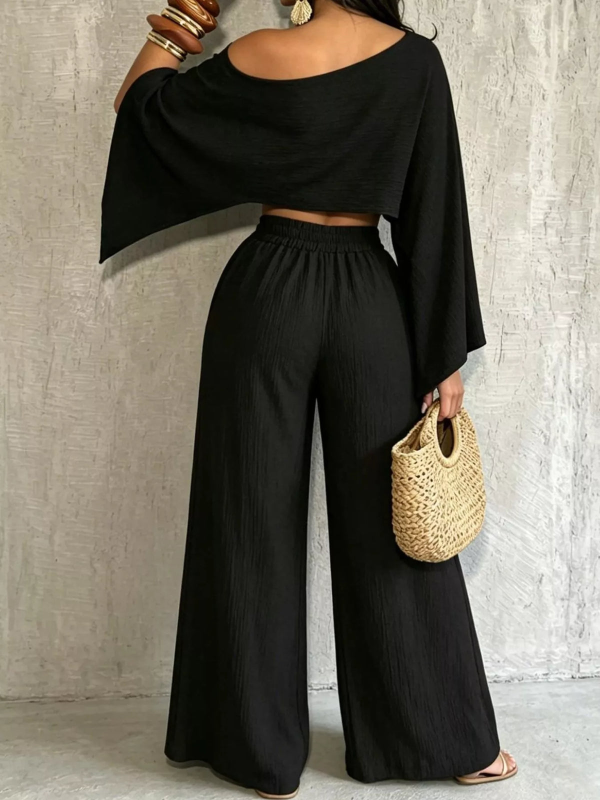 Black boat-neck crop top and wide-leg pants set with flowing sleeves and elastic waist