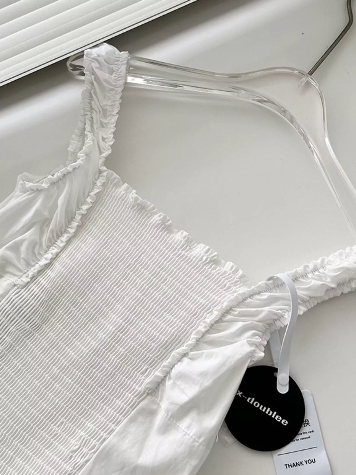 White ruffled square-neck cotton maxi dress on hanger with thin tie straps