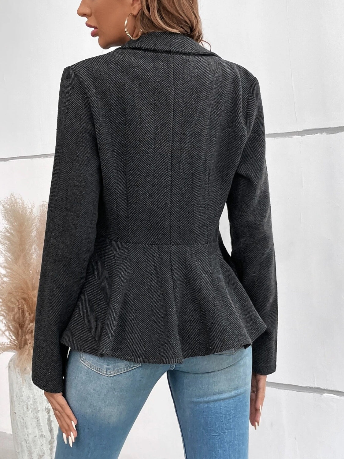 Dark charcoal collared blazer with ruffle peplum hem, back view