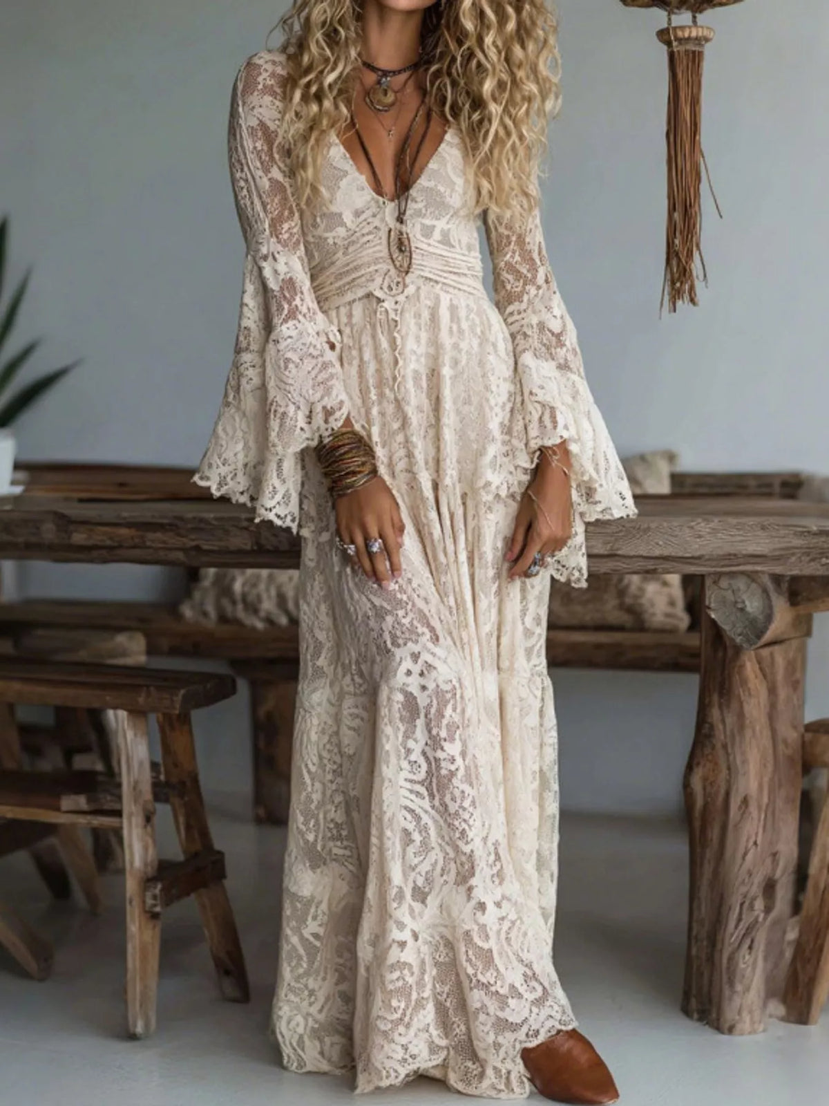Maxi lace dress with ruched V-neckline and long flare sleeves, cream tone.