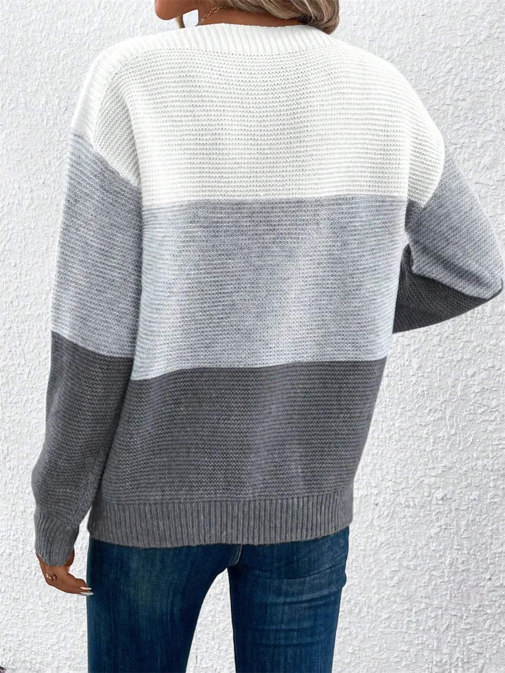 Back view of color-block long sleeve sweater in white and gray knit horizontal bands