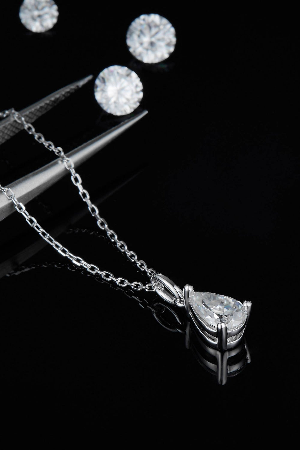 Sterling silver necklace with teardrop moissanite pendant in prong setting and chain links