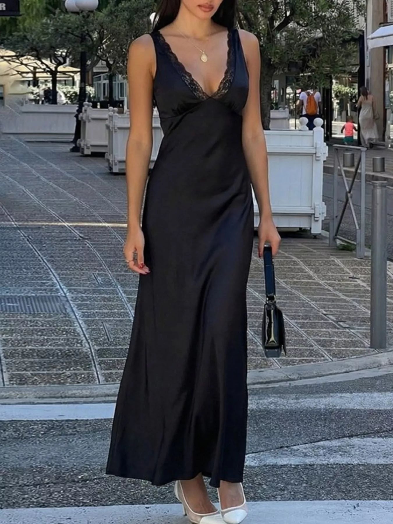 Black lace V-neck sleeveless maxi dress with a smooth sheen and long, fitted skirt.