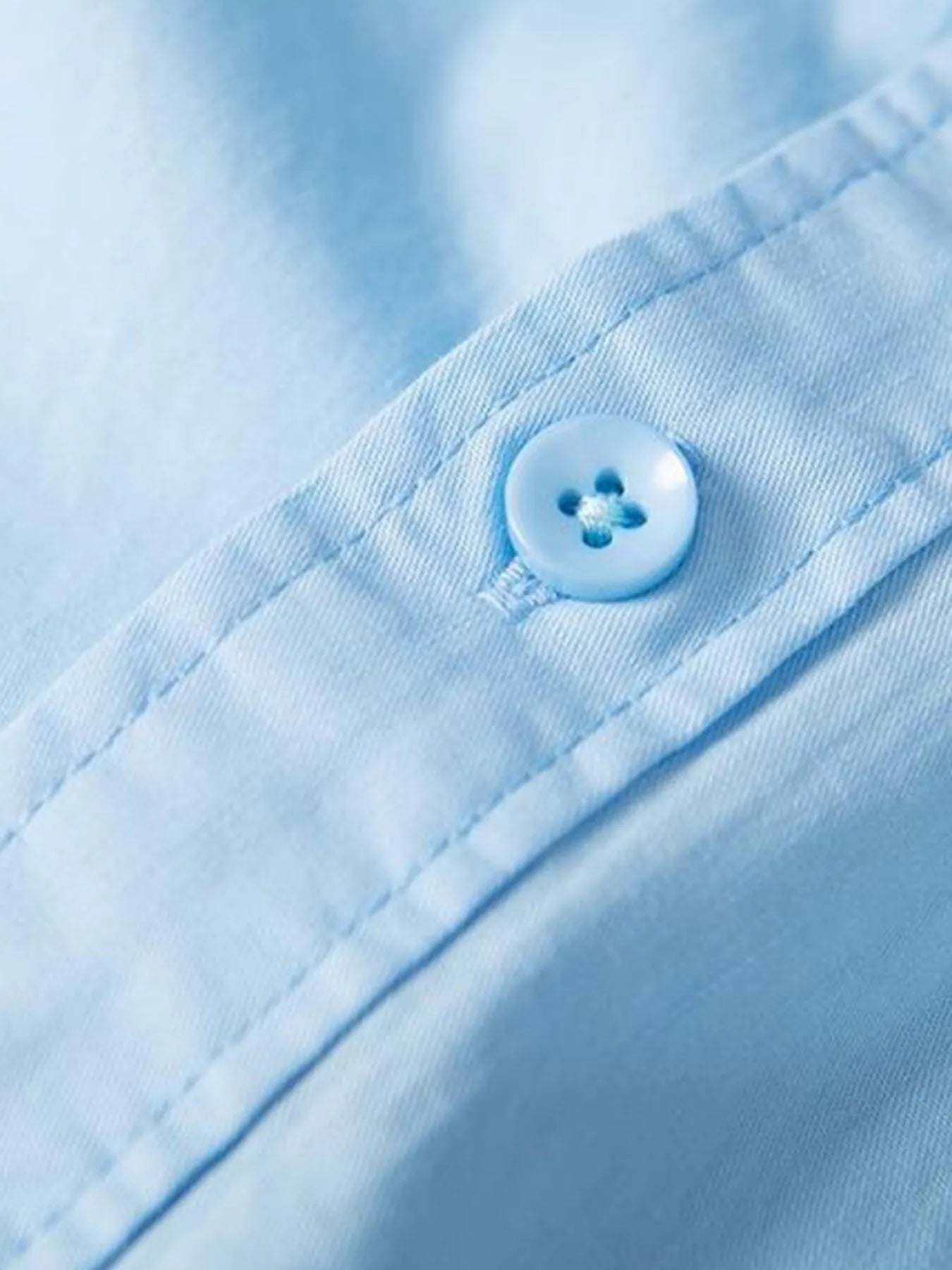 Light blue shirt cuff with round button and stitched placket