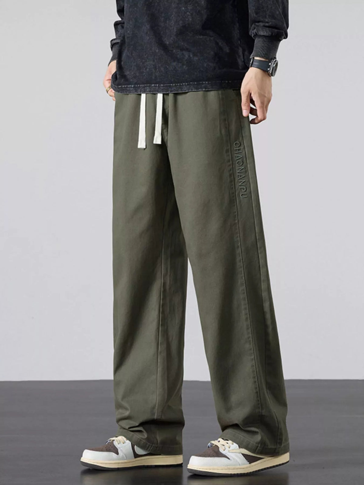 Mens army green wide-leg casual pants with elastic waist and white drawstring ties