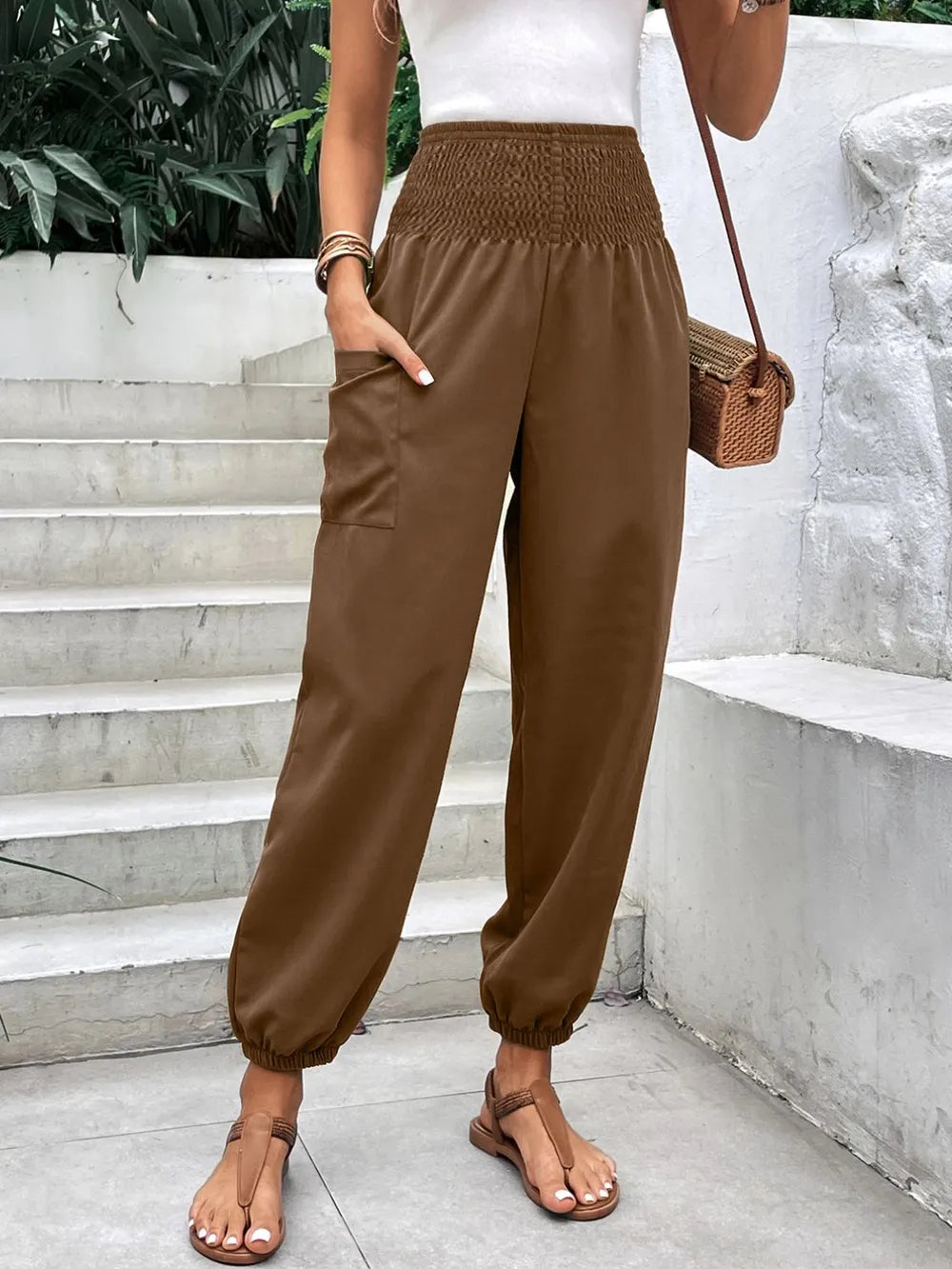 Brown smocked high-rise joggers with side pockets and gathered ankle cuffs