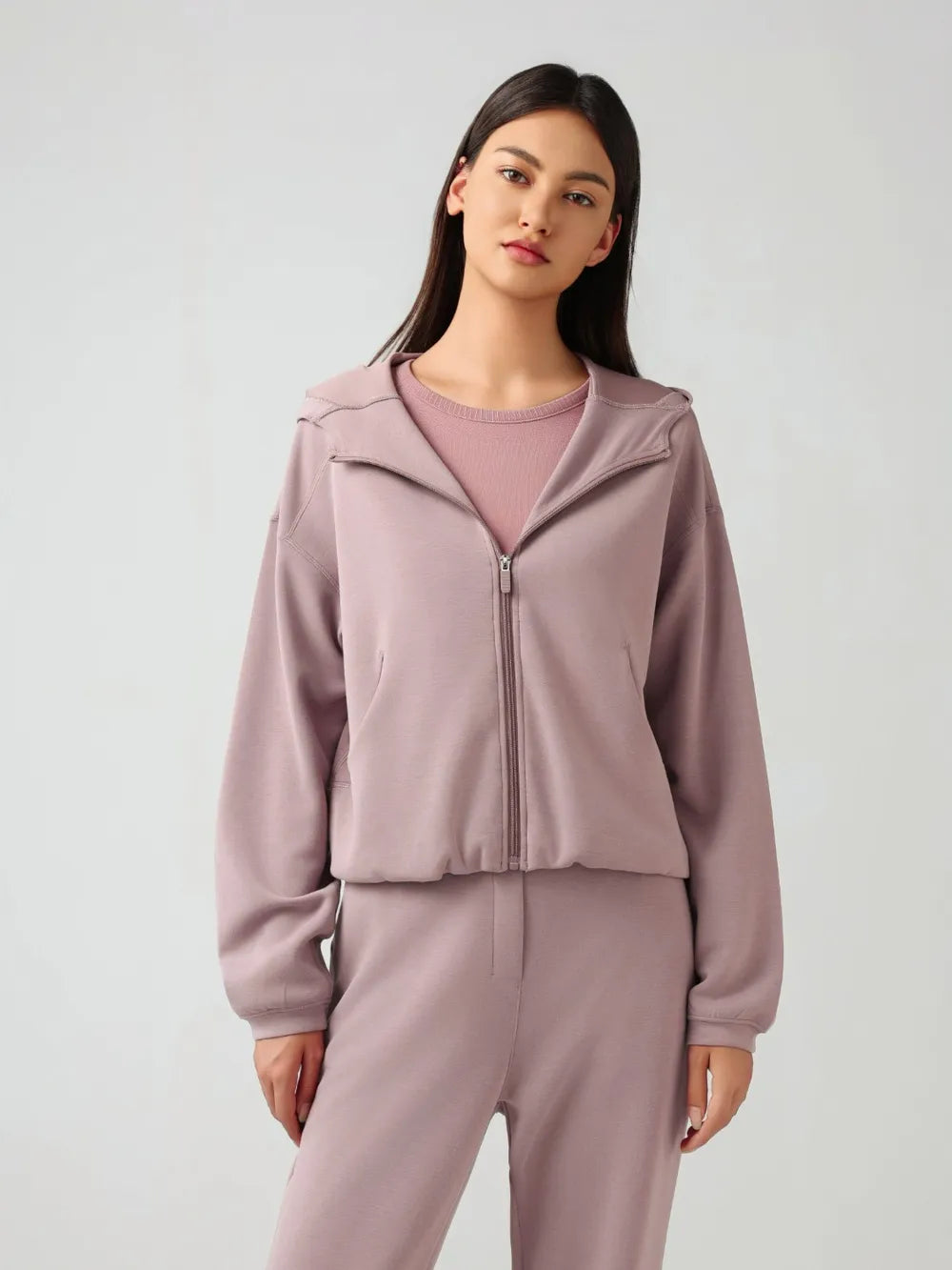 Dusty pink zip-up active hoodie with hood, full front zipper, and dropped-shoulder fit