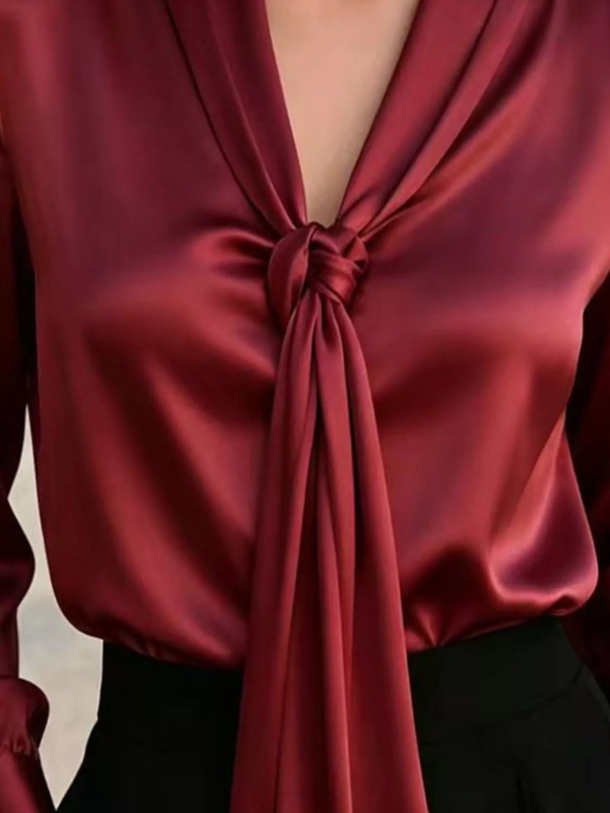 Burgundy satin blouse close-up of front tie bow at V-neck