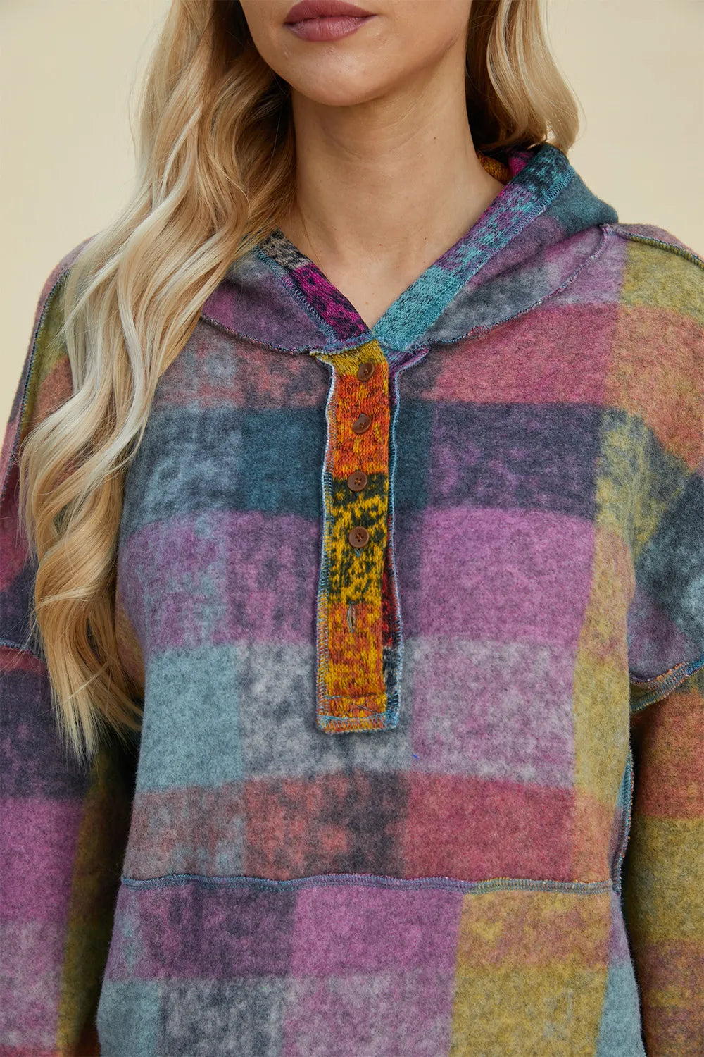 Plaid fleece hoodie close-up with hood and half-zip placket, multicolor patchwork