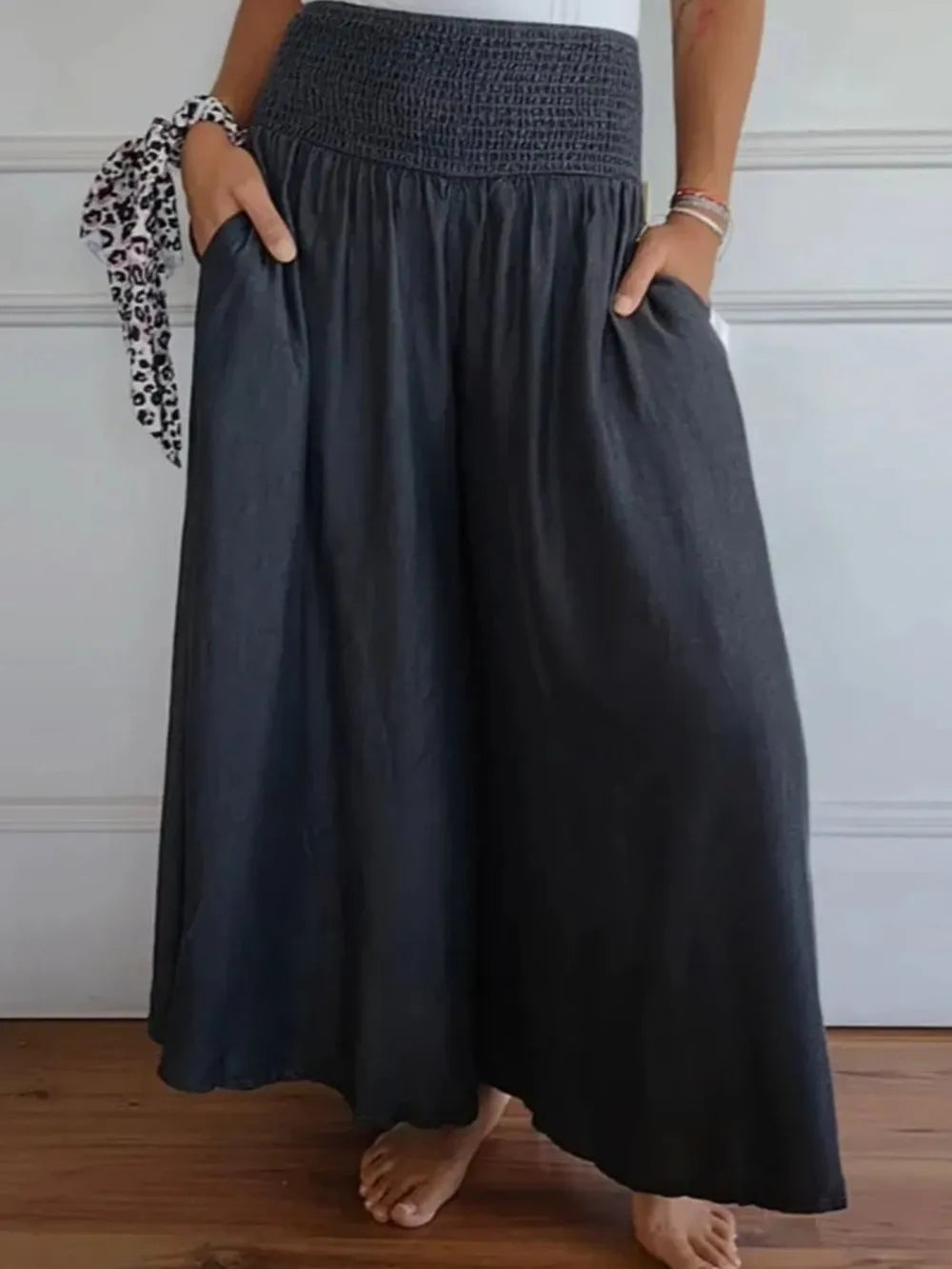 Black smocked wide-leg pants with gathered waist and flowing drape