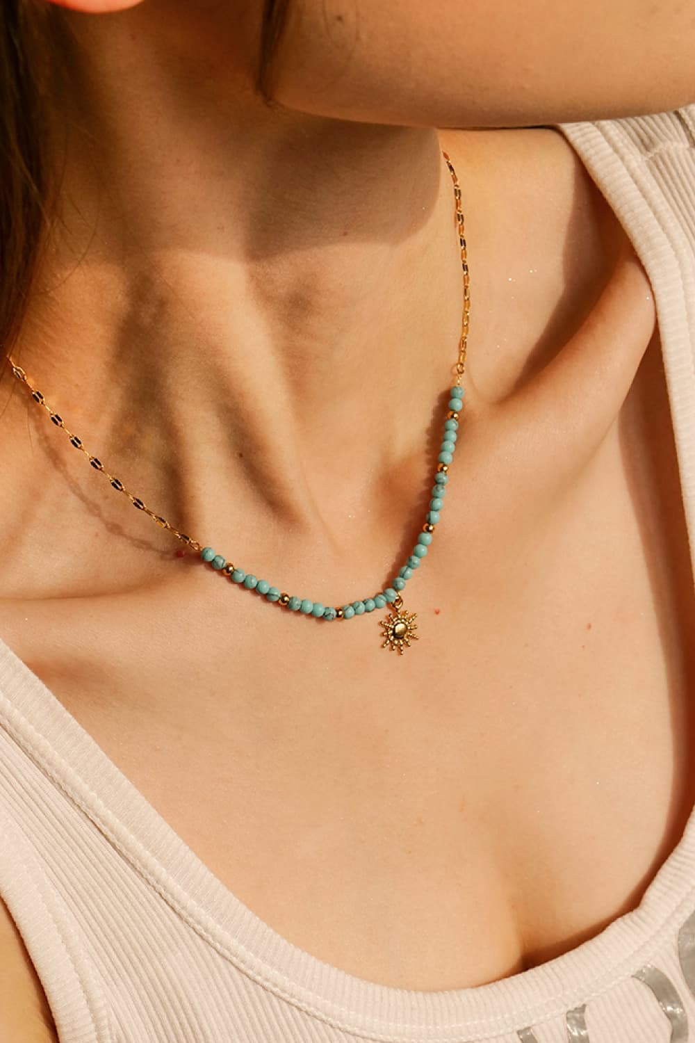 Turquoise beaded gold necklace with small sun pendant at the center