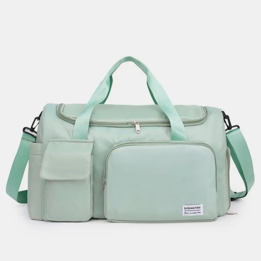 Large travel duffle bag with detachable straps, mint green with front zip compartment.