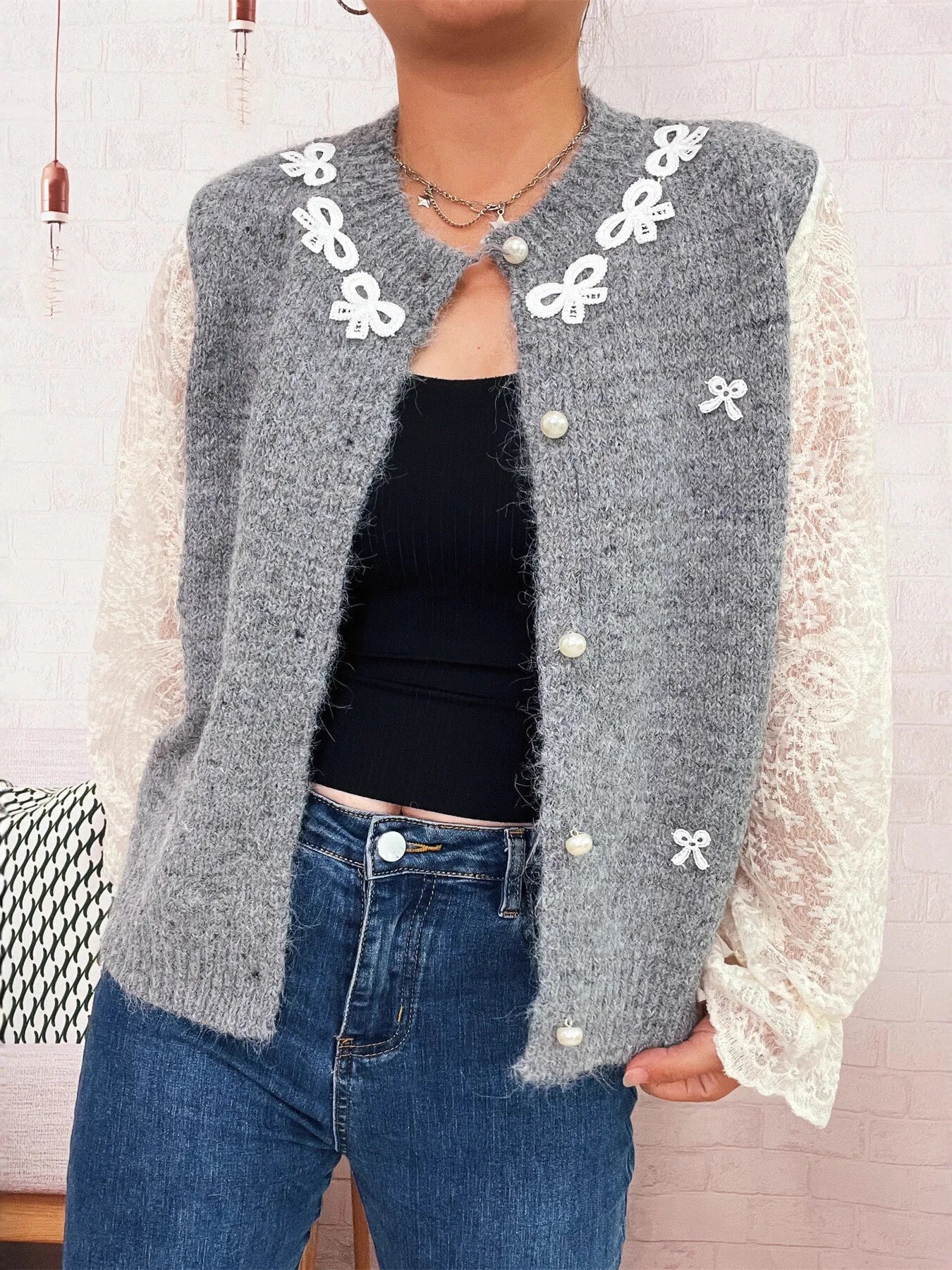 Gray lace-sleeve button-up cardigan with lace cuffs, bow trim, and pearl-style buttons