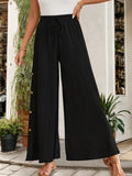 Tied slit wide-leg pants in black with elastic waistband, pinstripe texture, side buttons