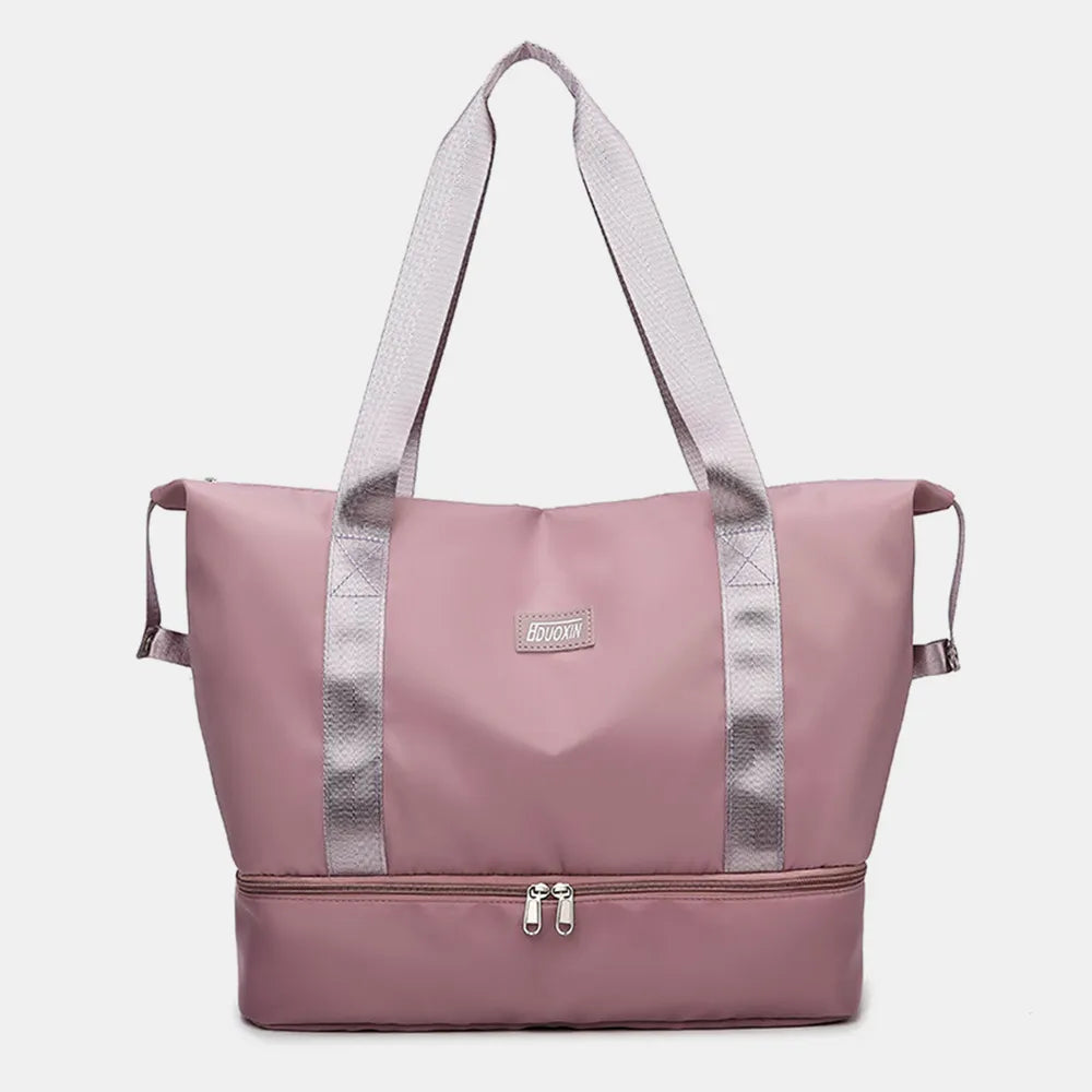 Dusty pink nylon travel duffel bag with wide straps and front zipper pocket.