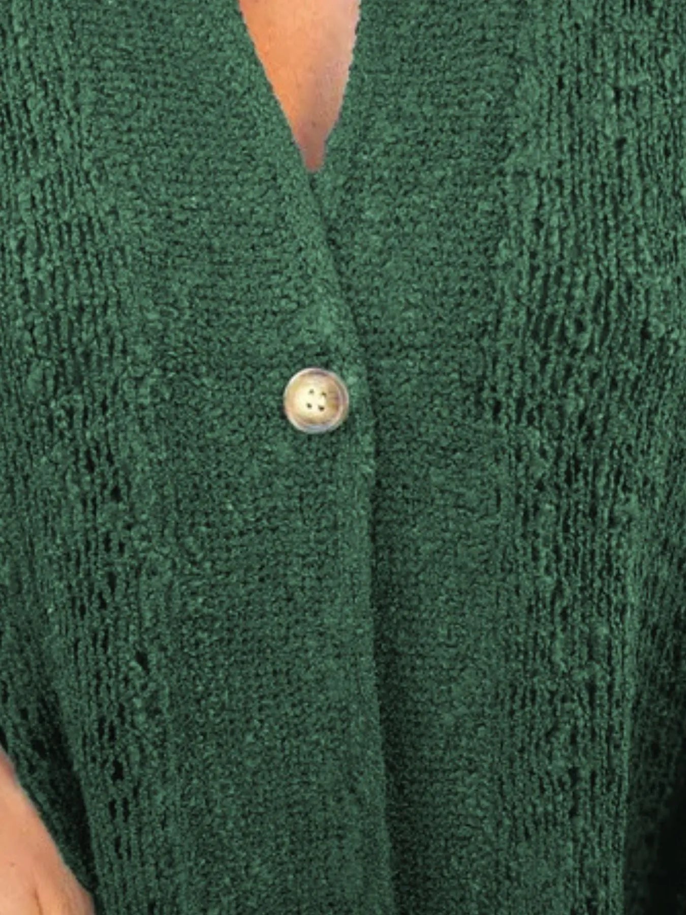 Green openwork cardigan close-up with V-neck and single button-front, textured knit