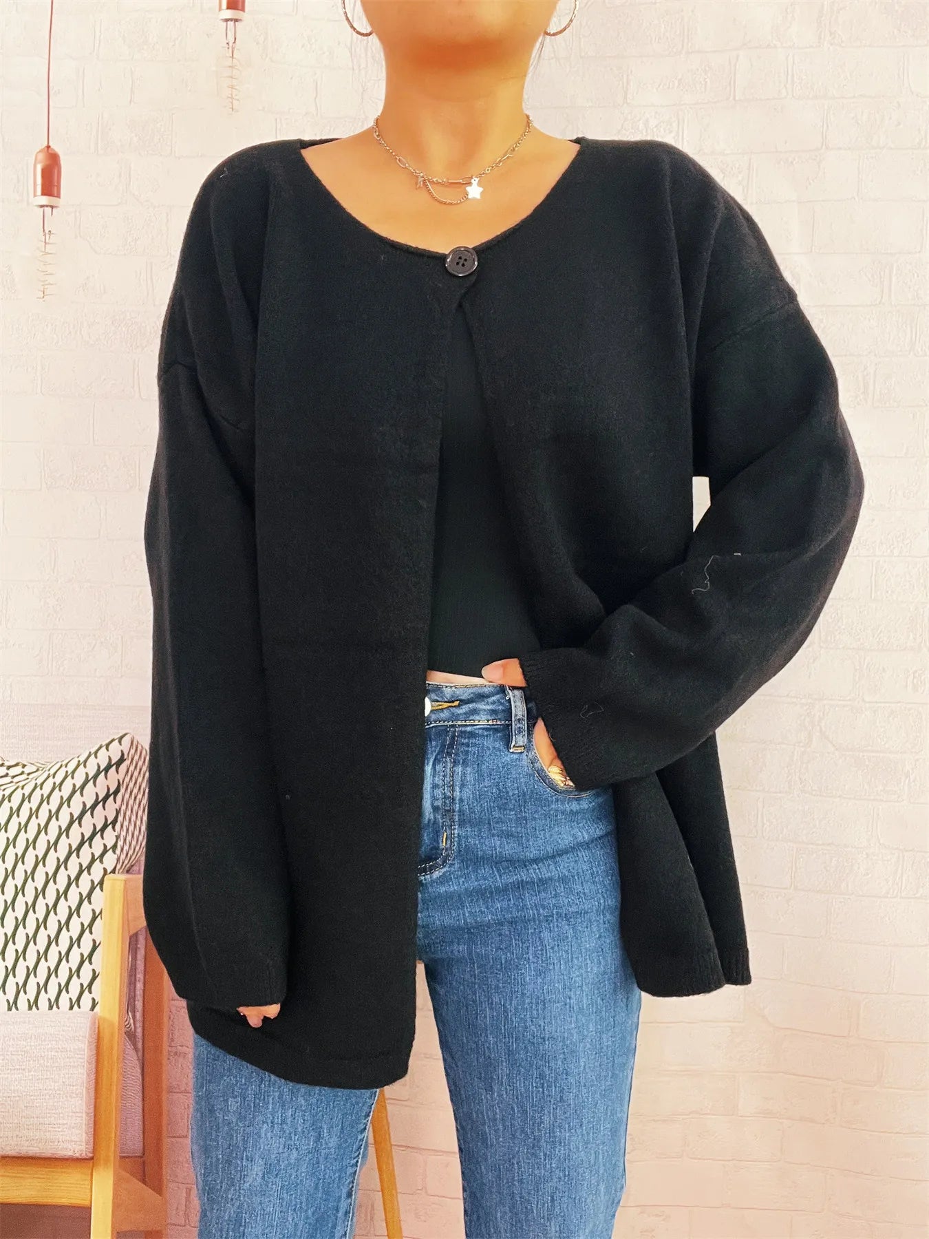 Black one-button drop-shoulder cardigan with single button placket and long sleeves